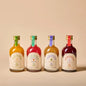 Vier 20 cl Mini-Flaschen Alkoholfreie Jardins Aperitifs in verschiedenen Farben und Etiketten.