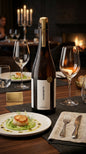 FOURCHETTE Grand Cru Sauvignon Blanc Weinflasche mit zwei gefüllten Weingläsern und Teller mit Garnele auf gedecktem Tisch.